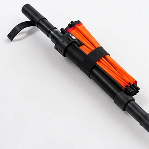 Concept of the compact orange canopy folded against a black hiking pole.
